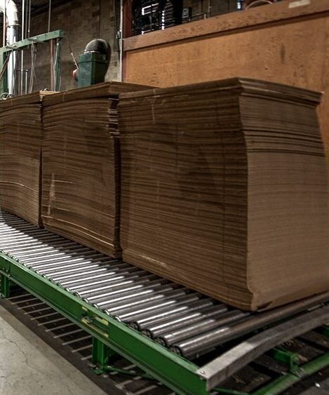 a stack of plywood moves across a roller table